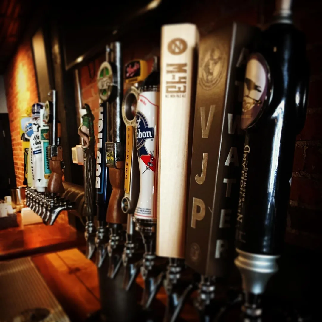 Beer tap handles lined up along the bar at Copper Athletic Club